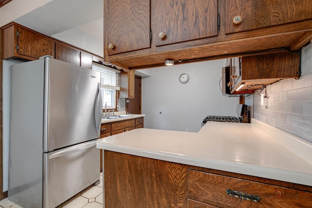 33170 N Battershall Rd, Grayslake, IL 60030 - kitchen featuring freestanding refrigerator, range with gas cooktop, backsplash, a peninsula, and light countertops