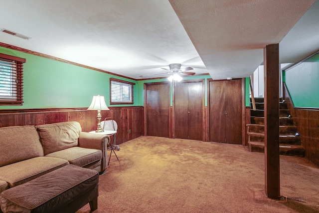 33170 N Battershall Rd, Grayslake, IL 60030 - carpeted living room featuring wooden walls, stairs, wainscoting, ceiling fan, and crown molding