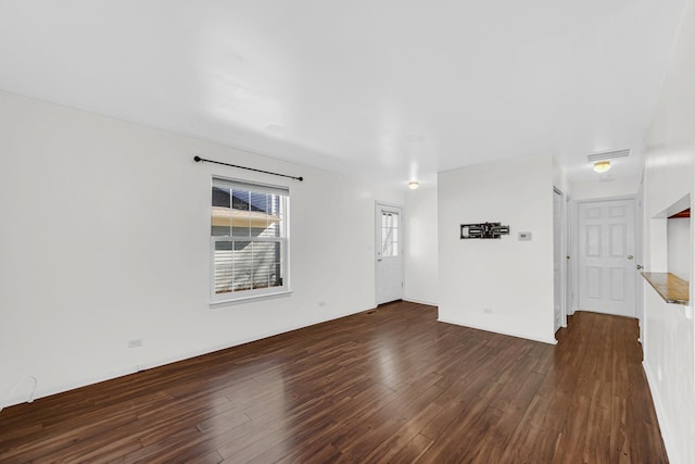 unfurnished living room with dark wood finished floors and visible vents
