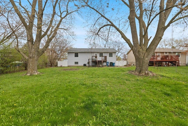 exterior space featuring a wooden deck, a fenced backyard, and a yard