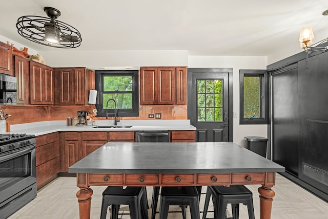 5802 Tennessee Ave, Clarendon Hills, IL 60514 - kitchen featuring appliances with stainless steel finishes, pendant lighting, a kitchen bar, and a sink