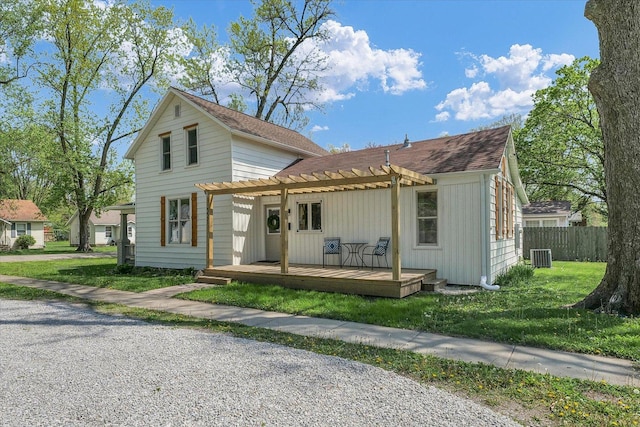 view of front of house with fence, a pergola, a front yard, a wooden deck, and cooling unit