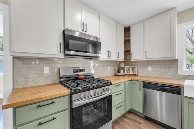 kitchen with butcher block countertops, green cabinetry, and appliances with stainless steel finishes
