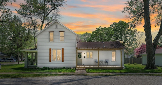 traditional-style home featuring fence, board and batten siding, and a shingled roof