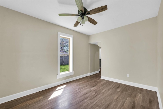 empty room with baseboards, ceiling fan, and wood finished floors