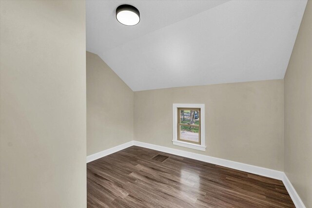bonus room with dark wood-type flooring, baseboards, and lofted ceiling