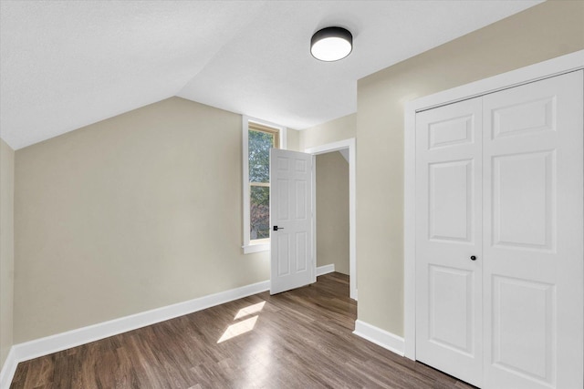 bonus room with baseboards, vaulted ceiling, and wood finished floors