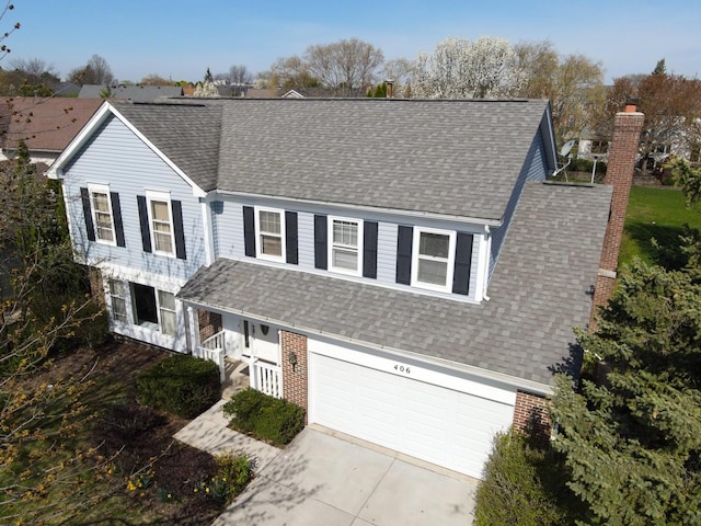 406 Woodcroft Ln, Schaumburg, IL 60173 - traditional-style house featuring concrete driveway, an attached garage, roof with shingles, and a chimney