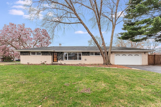 single story home with driveway, a front yard, brick siding, fence, and an attached garage