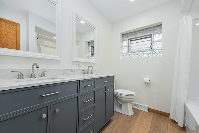 bathroom with toilet, visible vents, a sink, and wood finished floors