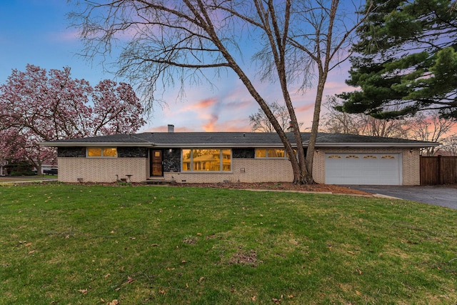 ranch-style house featuring a garage, fence, a front yard, brick siding, and driveway