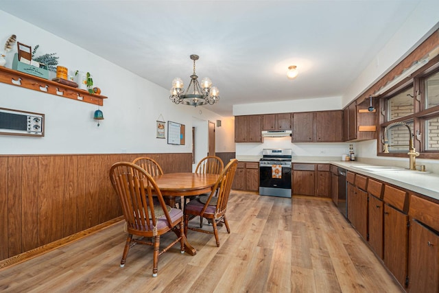 kitchen featuring open shelves, a sink, gas range, and light wood-style flooring