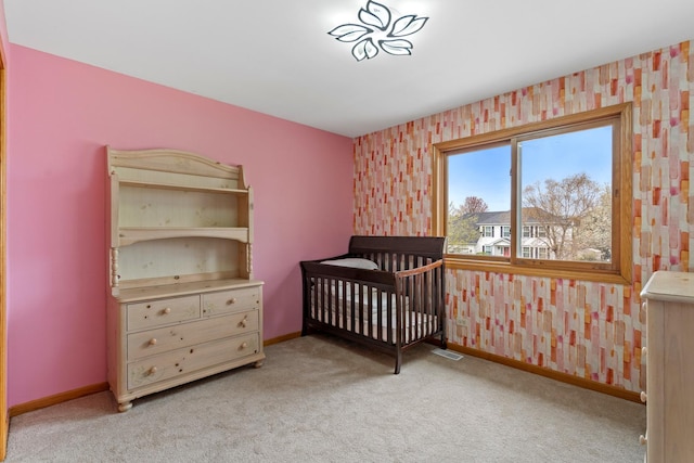 carpeted bedroom with visible vents, a crib, and baseboards