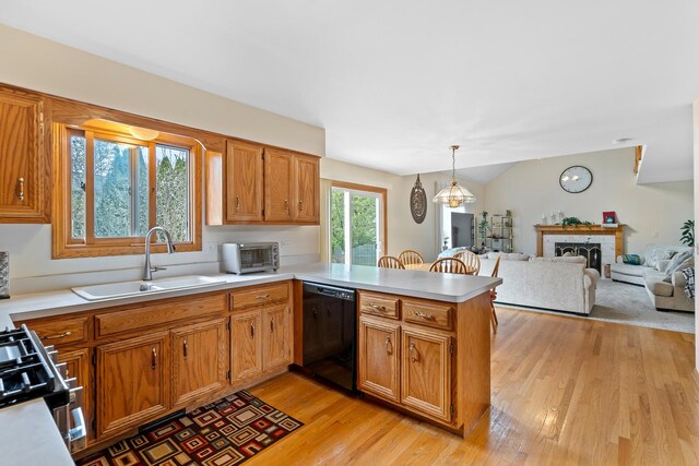 kitchen with range with gas stovetop, a sink, dishwasher, light countertops, and a peninsula