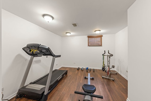 exercise room with visible vents, baseboards, and wood finished floors