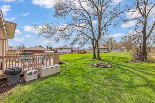 view of yard with a residential view, a fire pit, and a deck