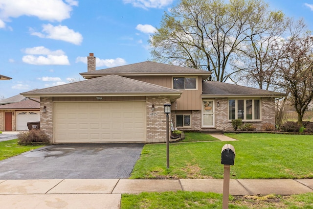view of front facade featuring a front lawn, aphalt driveway, a chimney, brick siding, and an attached garage