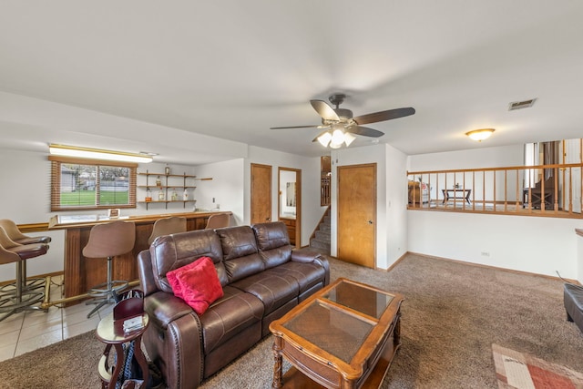 living area with baseboards, ceiling fan, visible vents, and a bar