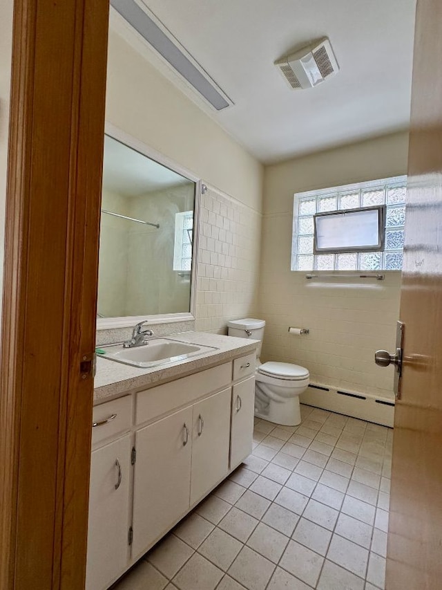 4941 N Kilpatrick Ave, Chicago, IL 60630 - bathroom featuring toilet, tile patterned floors, tile walls, a baseboard heating unit, and visible vents
