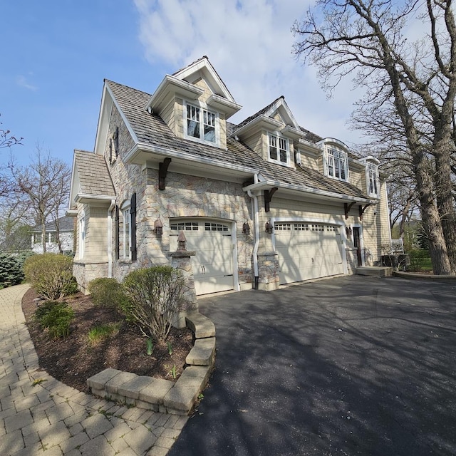 9065 Edinburgh Ct, Lakewood, IL 60014 - view of home's exterior with an attached garage, driveway, and stone siding