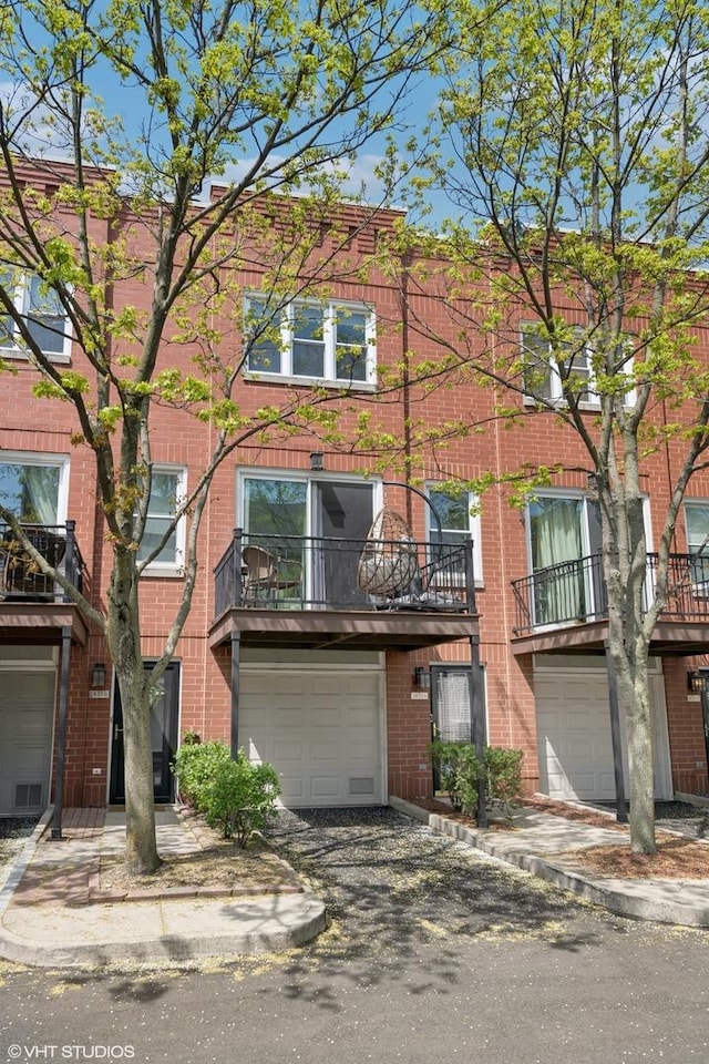 townhome / multi-family property featuring brick siding and a garage