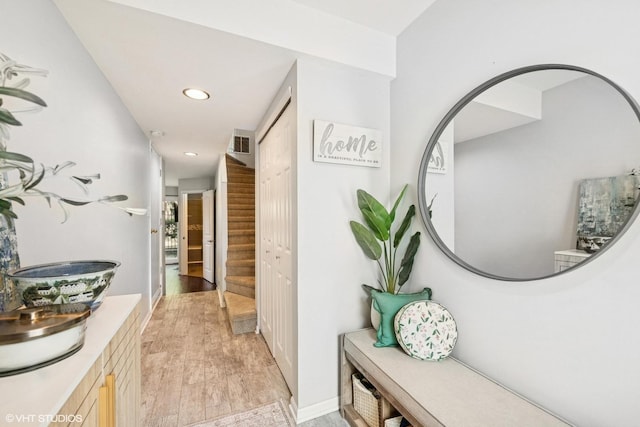 hallway featuring recessed lighting, light wood-type flooring, stairs, and visible vents
