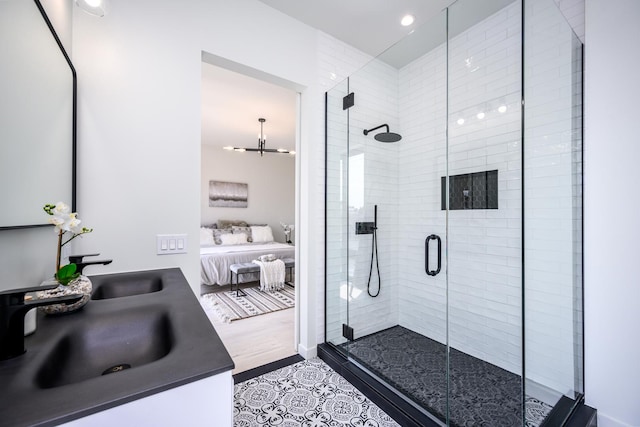 ensuite bathroom featuring a shower stall, a chandelier, ensuite bathroom, recessed lighting, and vanity