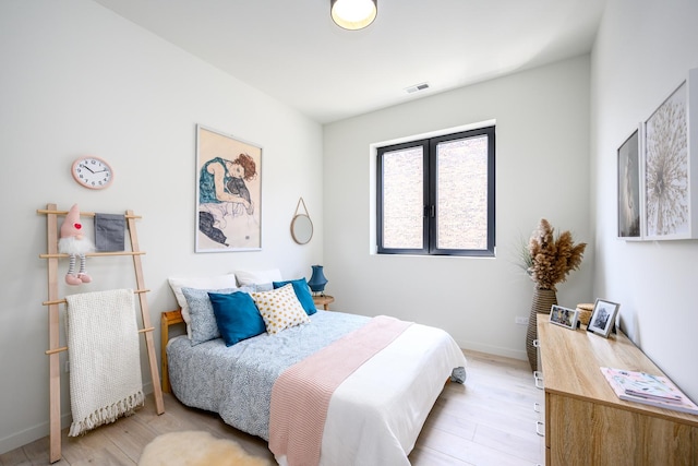 bedroom with visible vents, light wood-style flooring, and baseboards