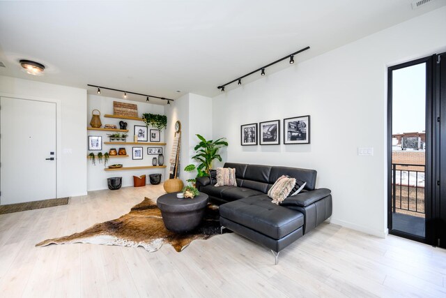 living room with rail lighting, wood finished floors, and visible vents