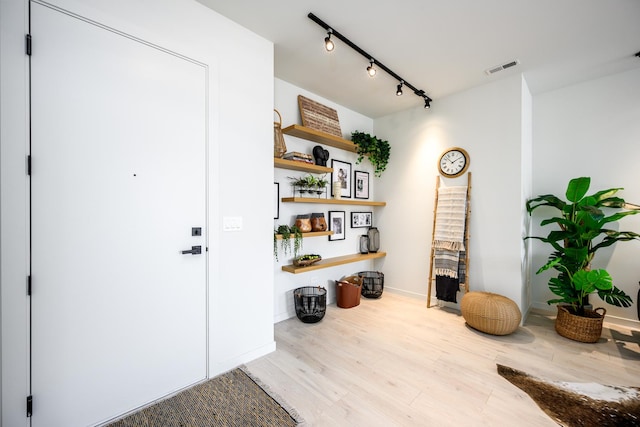 foyer with track lighting, visible vents, and wood finished floors