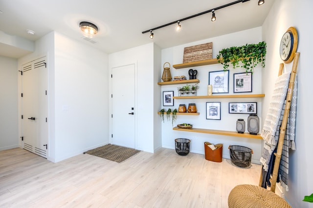 entryway with visible vents, wood finished floors, and baseboards