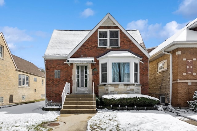 tudor-style house featuring brick siding