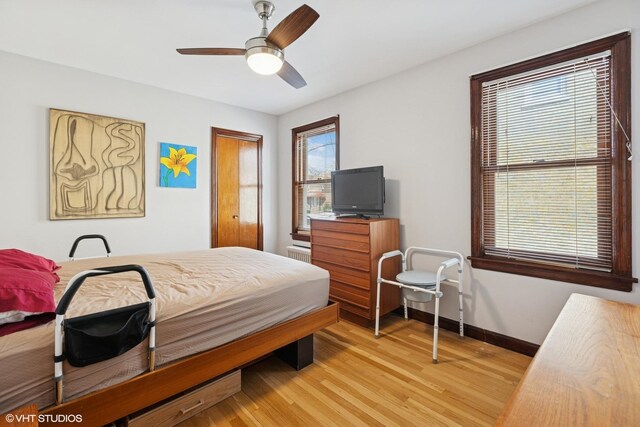 bedroom featuring light wood-style flooring, baseboards, and ceiling fan