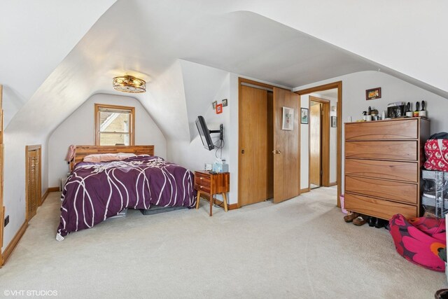 bedroom with vaulted ceiling, baseboards, carpet, and a closet
