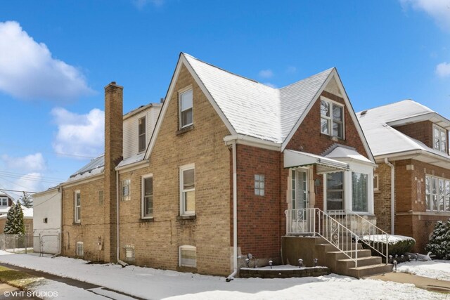 view of front of house featuring brick siding and a chimney