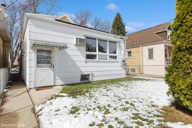 snow covered rear of property with fence