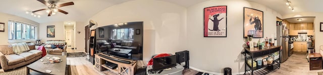 living area featuring baseboards, a ceiling fan, arched walkways, and lofted ceiling