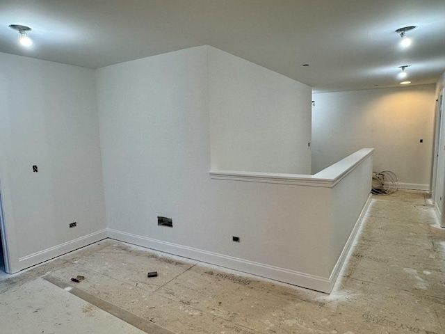 unfurnished room with baseboards