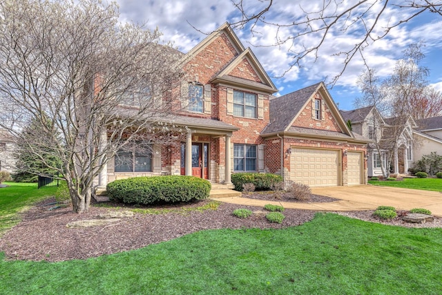 traditional home with brick siding, concrete driveway, a front yard, and a garage