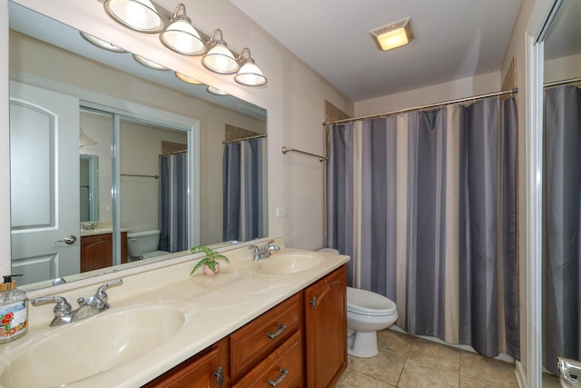 full bathroom featuring toilet, tile patterned floors, and double vanity