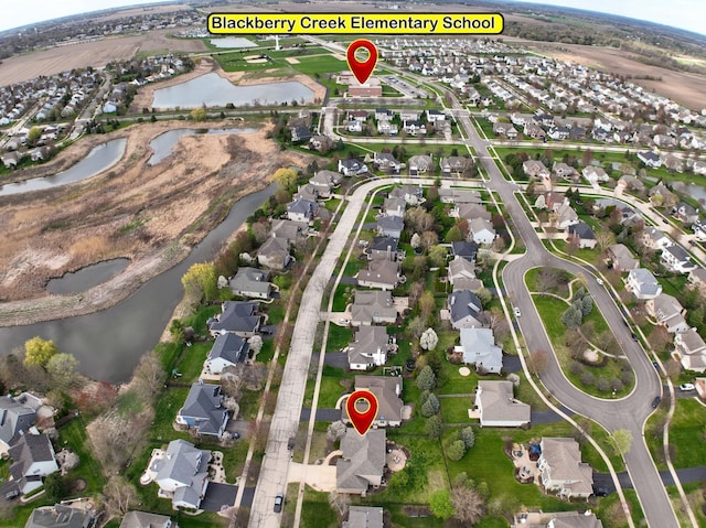 aerial view of property and surrounding area with nearby suburban area and a large body of water