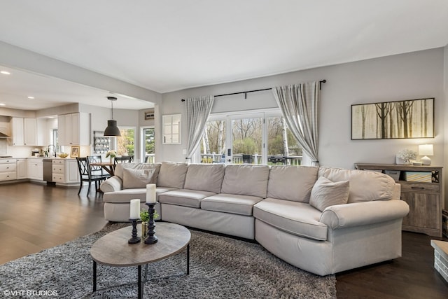 living room with recessed lighting and dark wood-type flooring