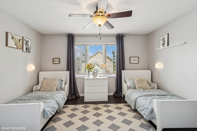 bedroom featuring baseboards, ceiling fan, and dark wood-type flooring