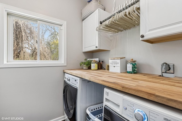 laundry area with baseboards, cabinet space, and washer and dryer