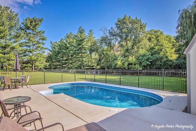 view of pool with a lawn, fence, a fenced in pool, and a patio area
