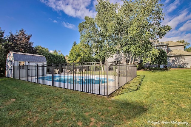 view of pool with a lawn, an outbuilding, fence, a fenced in pool, and a patio