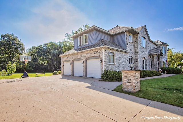 view of home's exterior with a garage, a yard, driveway, and stone siding