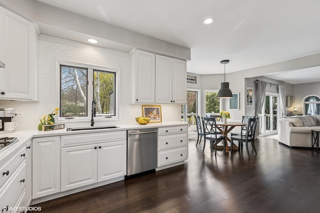 kitchen featuring a sink, stainless steel dishwasher, backsplash, and open floor plan