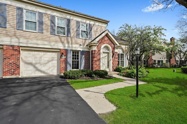view of front of home with brick siding, driveway, a front lawn, and a garage