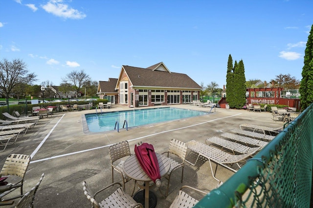 community pool featuring fence and a patio area